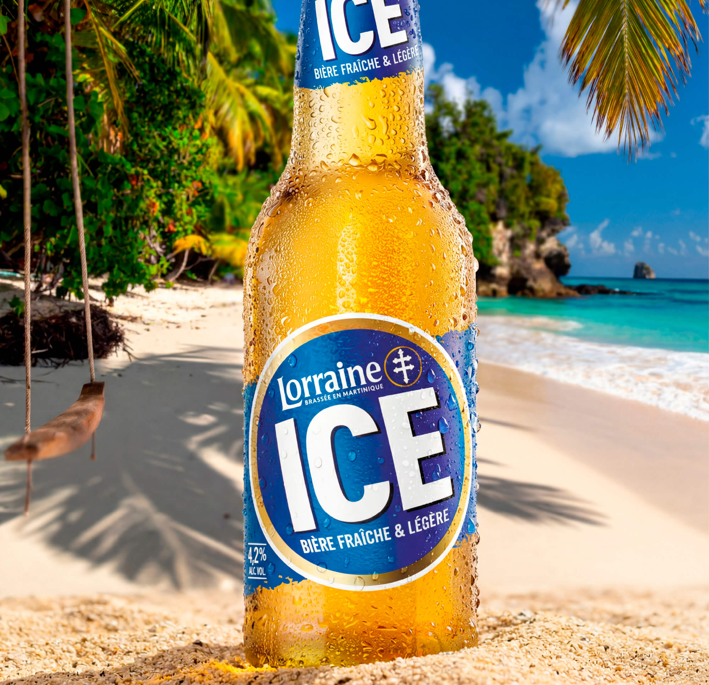 Bière Lorraine Ice posée dans le sable avec décor de plage situé en Martinique