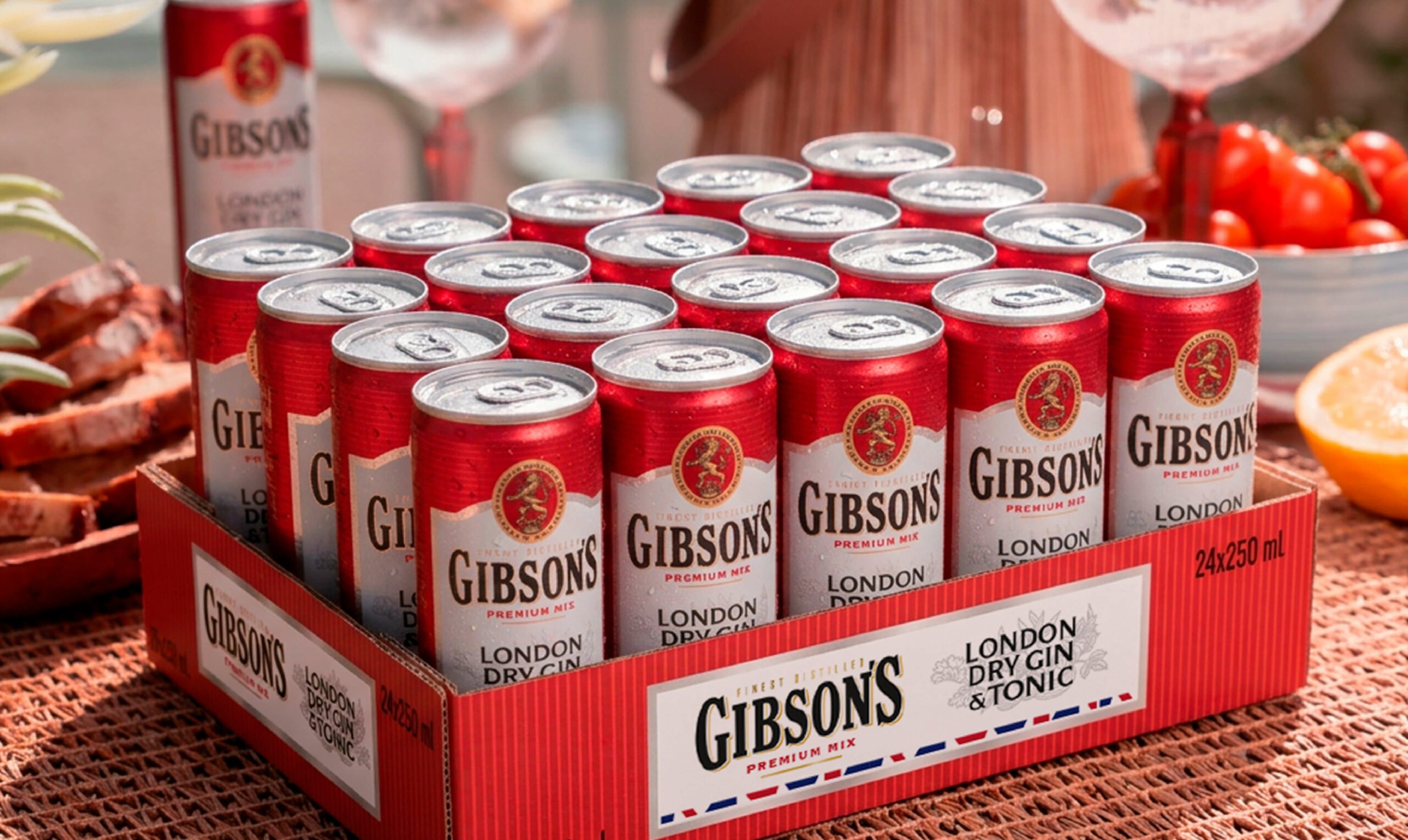 Barquette en carton, contenant des canettes Gibson's, posée sur une table de jardin